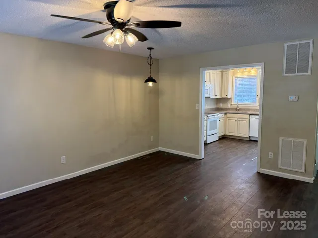 a view of a kitchen with a sink dishwasher a kitchen island with wooden floor and cabinets