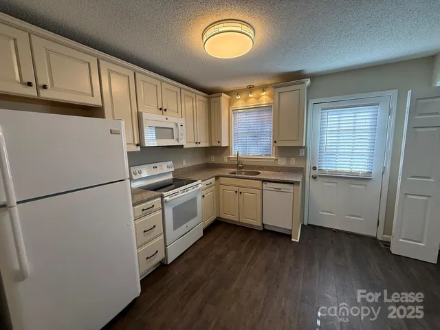 a kitchen with white cabinets and white appliances