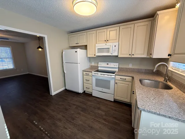 a kitchen with a refrigerator sink and cabinets