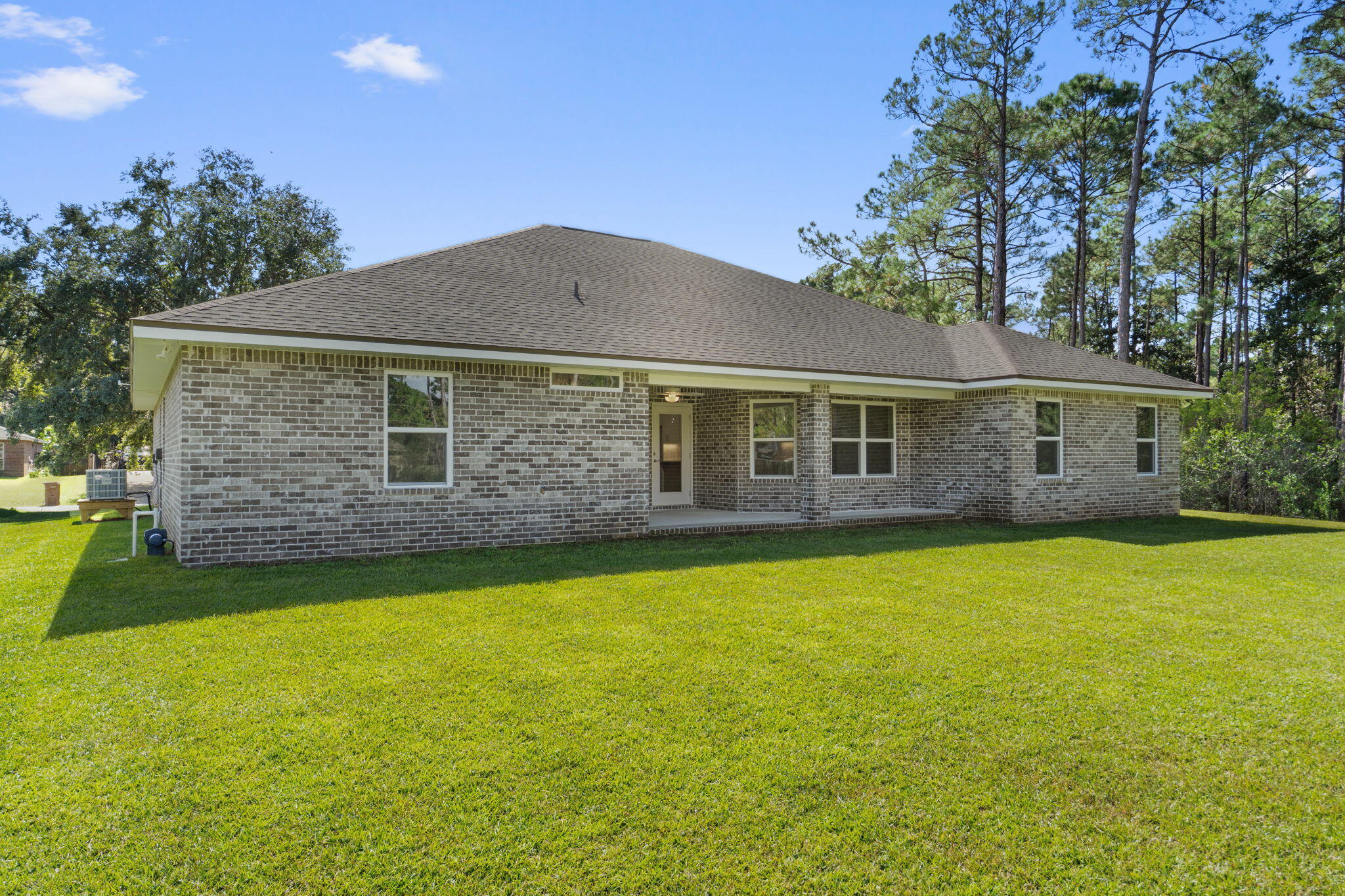 6752 Redfield Street Navarre, FL 32566 - Photo 44 of 64 a front view of a house with a garden