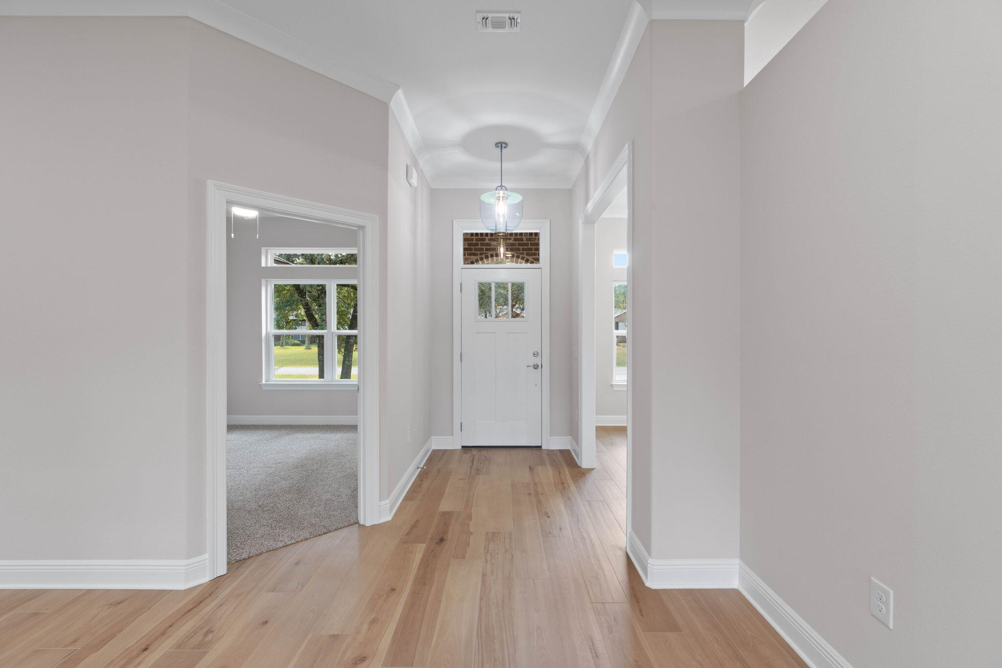 6752 Redfield Street Navarre, FL 32566 - Photo 5 of 64 a view of a hallway with wooden floor and a bathroom