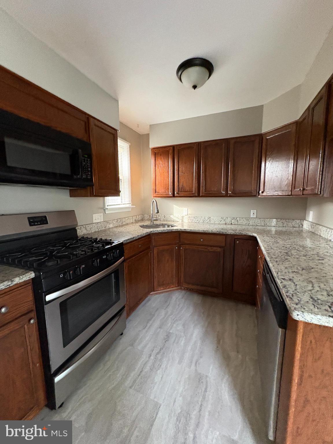 228 Phillips Avenue Runnemede, NJ 08078 - Photo 3 of 6 a kitchen with granite countertop a sink cabinets and stainless steel appliances