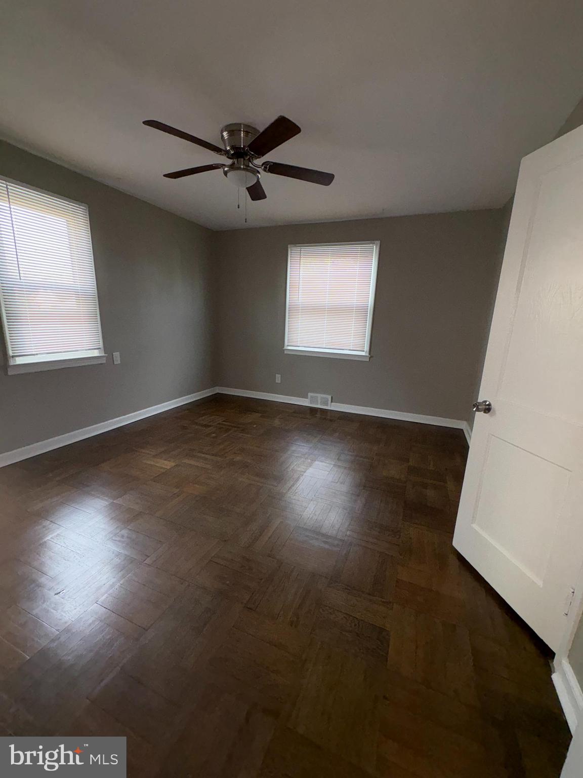 228 Phillips Avenue Runnemede, NJ 08078 - Photo 4 of 6 an empty room with wooden floor fan and windows