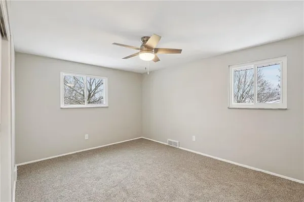 an empty room with a window and a ceiling fan
