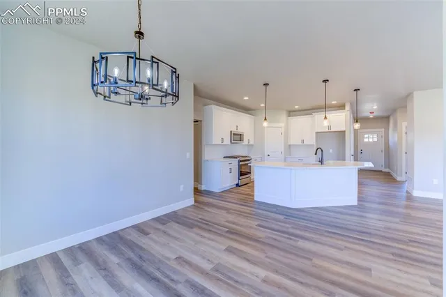 a view of kitchen and hall with wooden floor