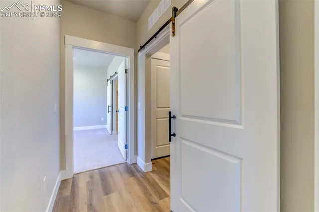a view of a hallway with wooden floor and entryway