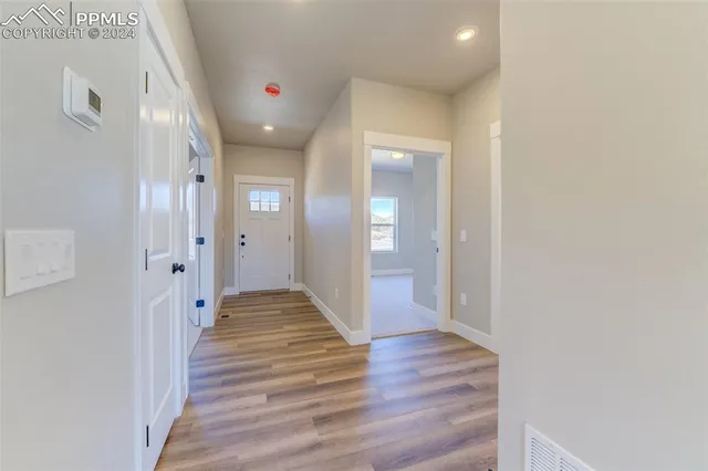 a view of a hallway with wooden floor and staircase