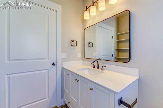 a bathroom with a sink vanity and a mirror