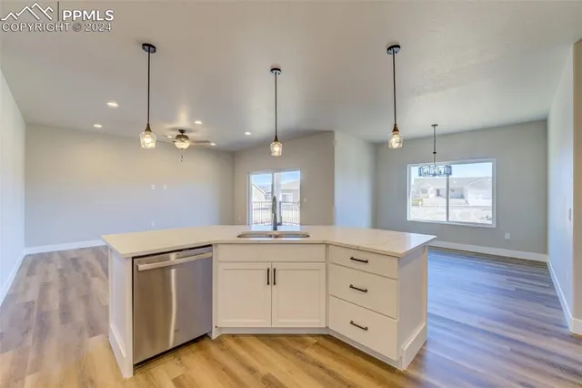 a kitchen with a white wooden cabinets sink and wooden floor