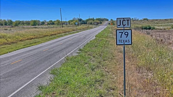 a view of a street with a yard and back yard