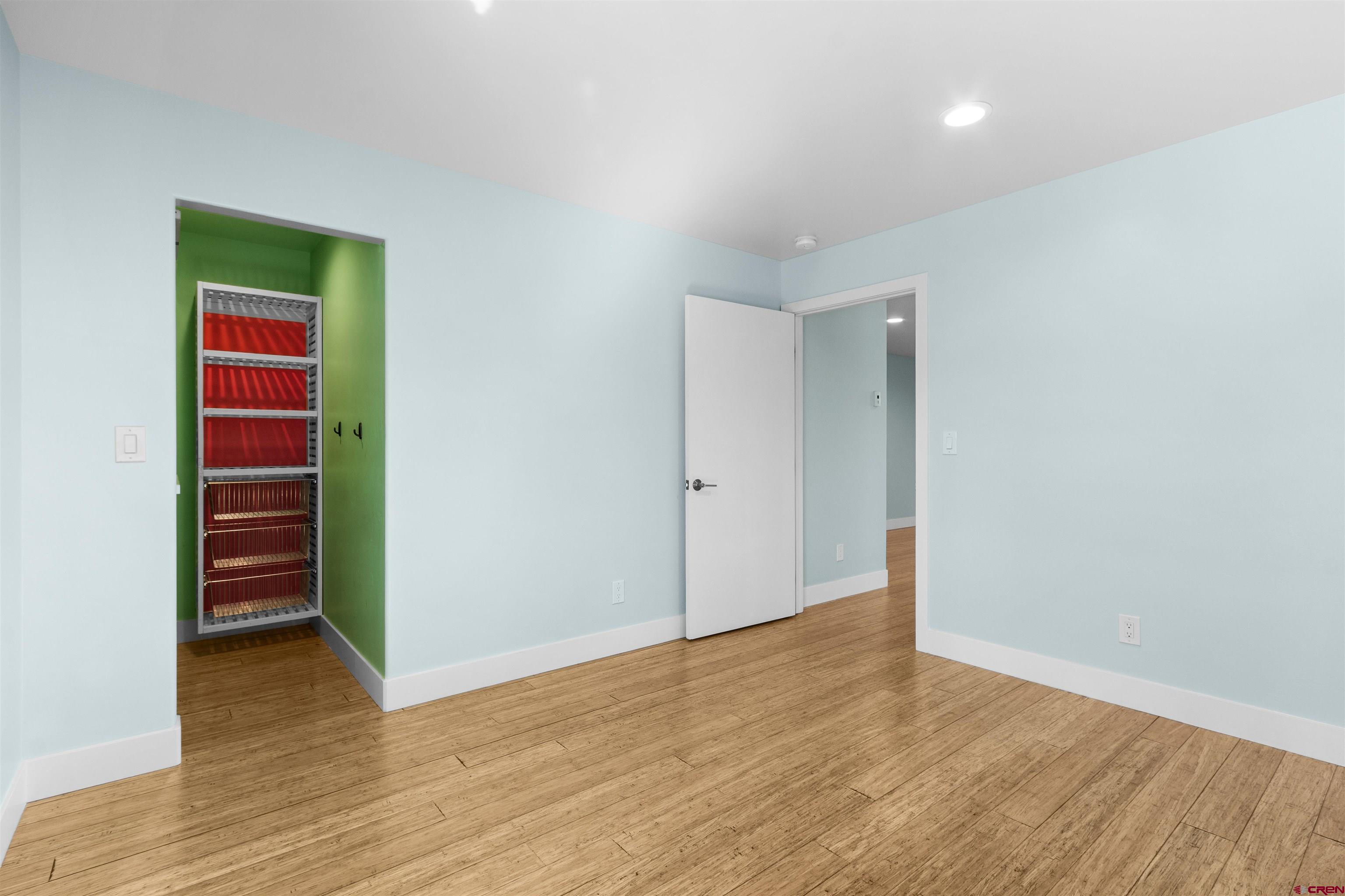 2192 Odelle Road Montrose, CO 81401 - Photo 25 of 45 a view of an empty room with wooden floor and a kitchen