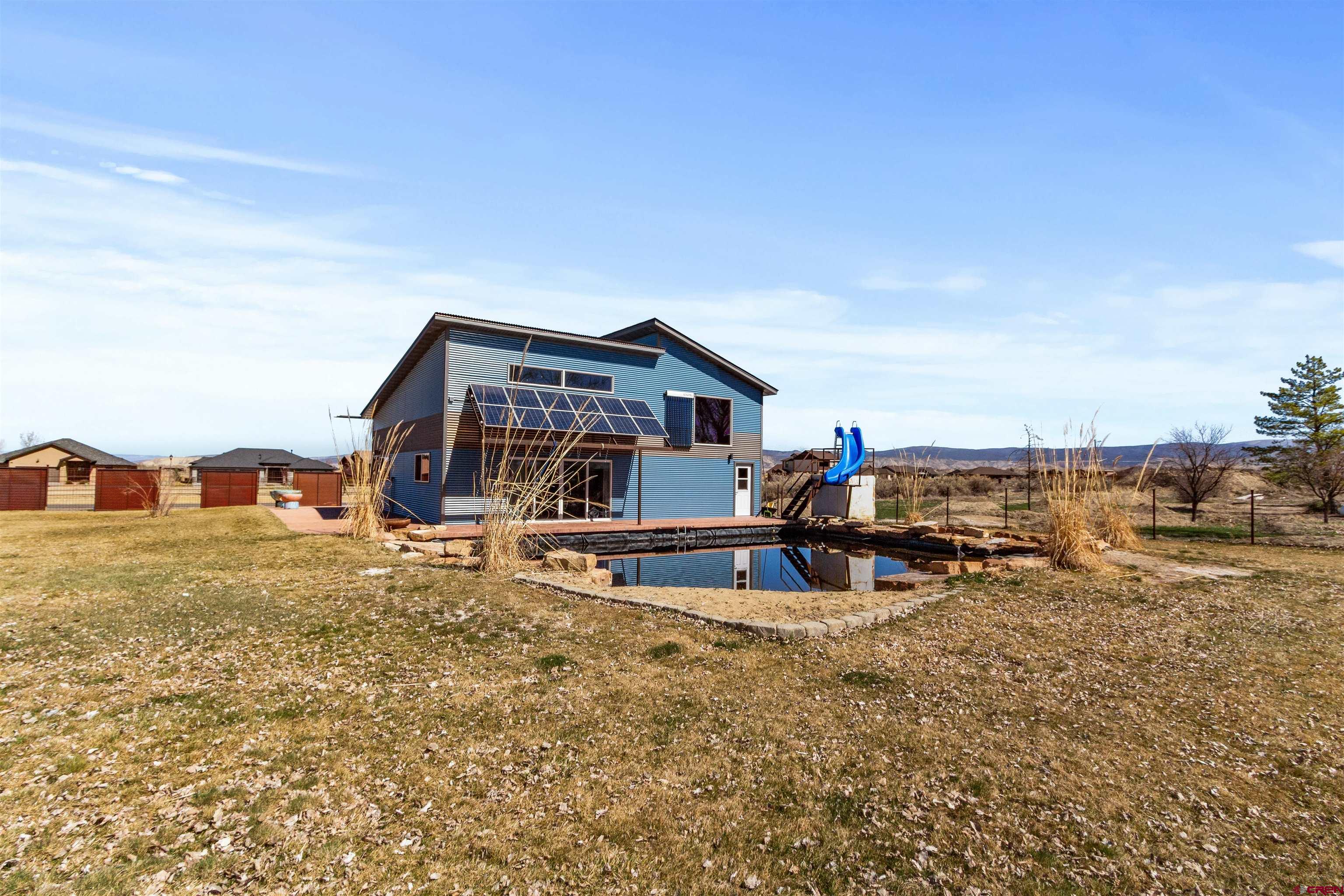 2192 Odelle Road Montrose, CO 81401 - Photo 42 of 45 a view of a house with a big yard and large trees