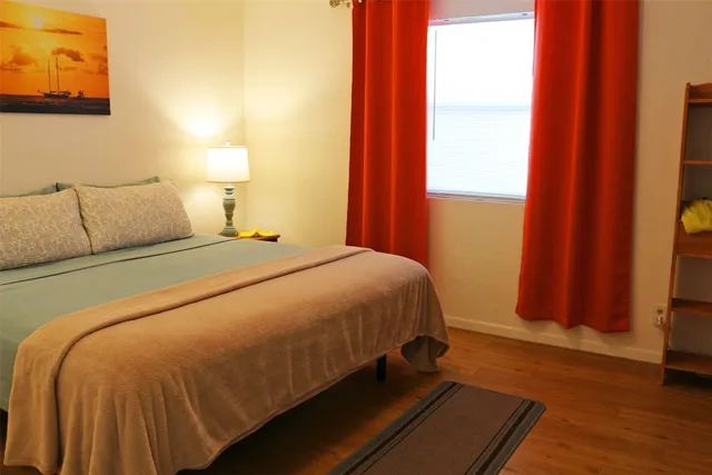 a bed sitting in a bedroom next to a window