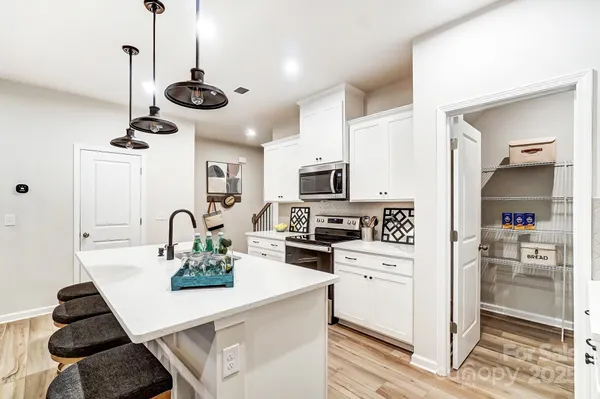 a kitchen with a refrigerator a stove and a wooden floor