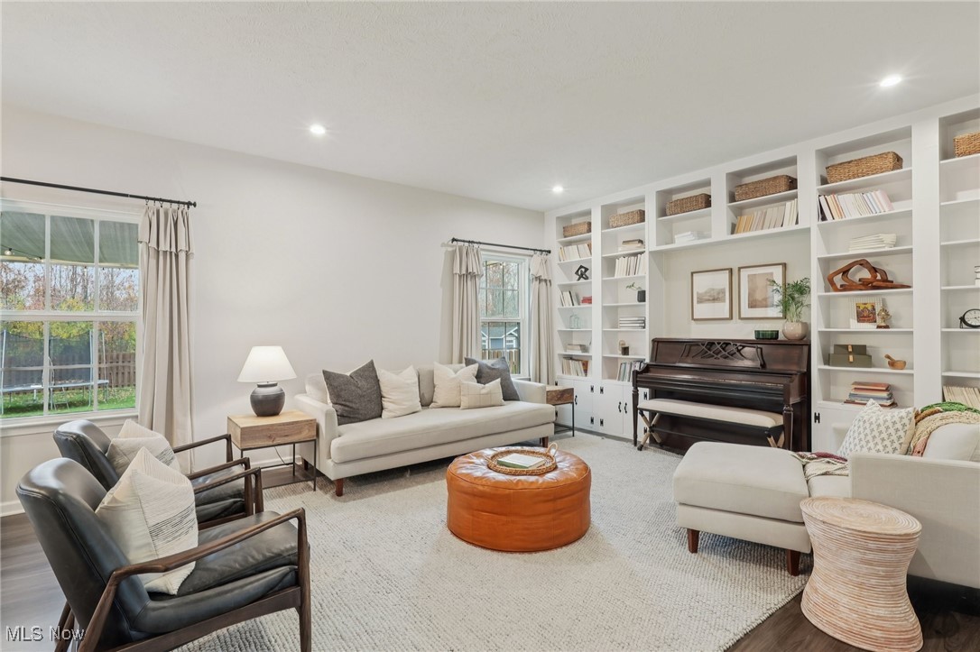 Living area with wood finished floors, recessed lighting, and built in features
