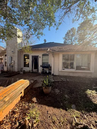 a view of a house with backyard sitting area and garden