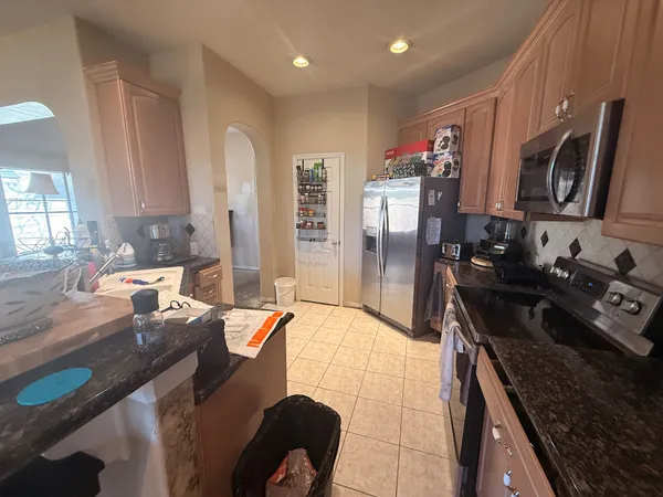 a kitchen with granite countertop a sink stove and refrigerator