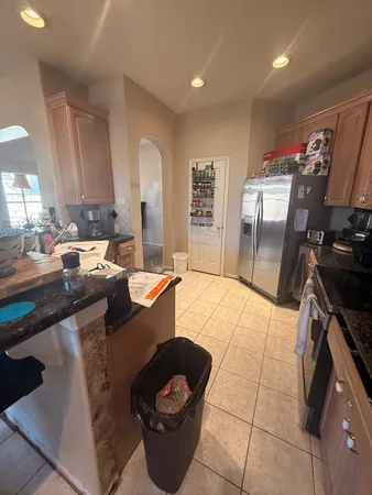 a kitchen with stainless steel appliances granite countertop a sink a stove a refrigerator a washer dryer and a dining table