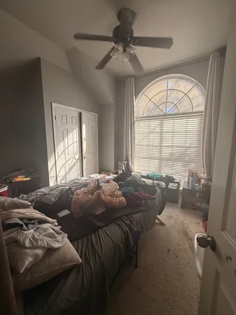 a bedroom with bed and a large window