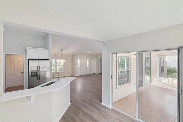 a view of a big room with wooden floor and windows