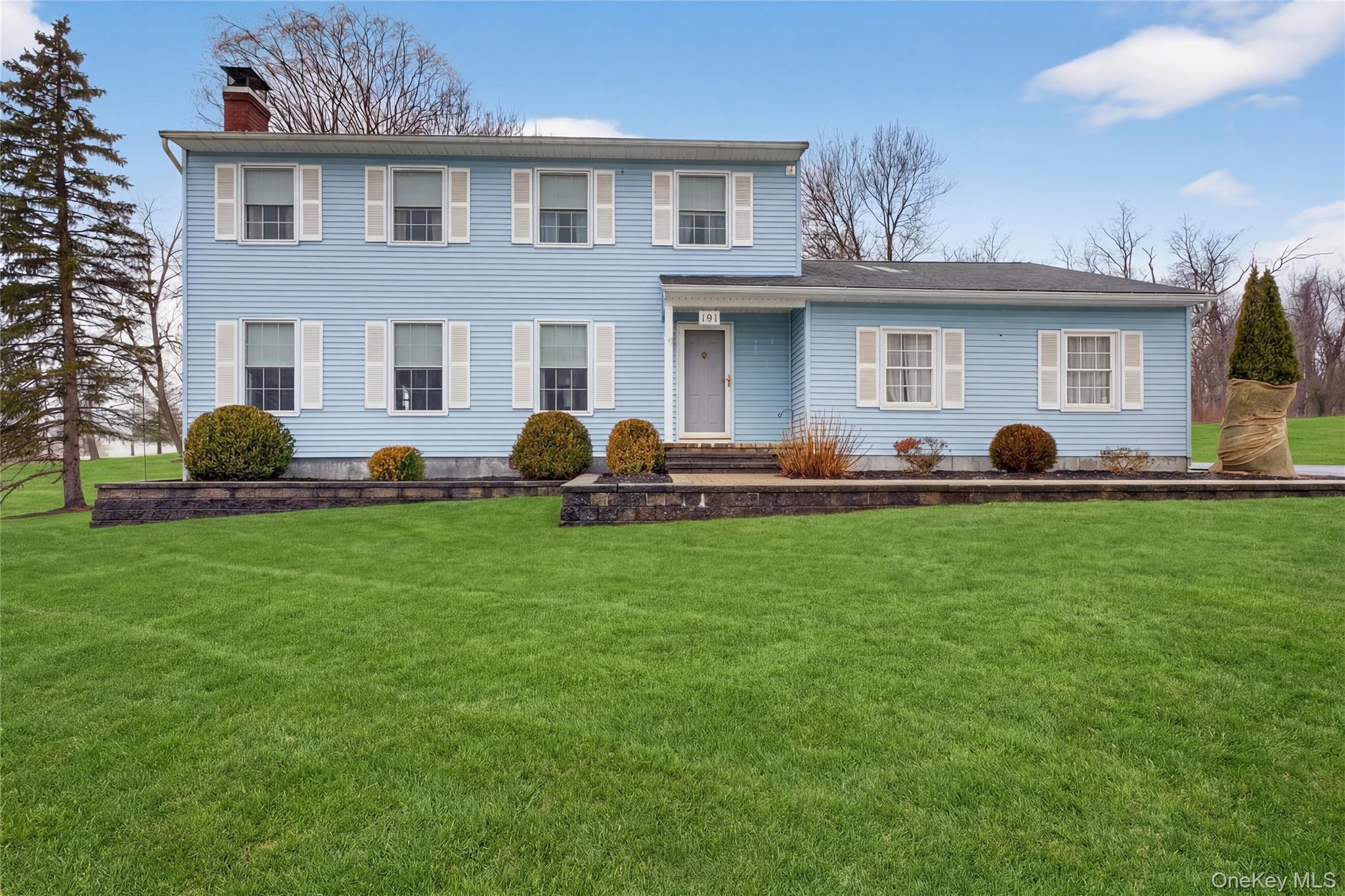 a front view of a house with a garden and yard