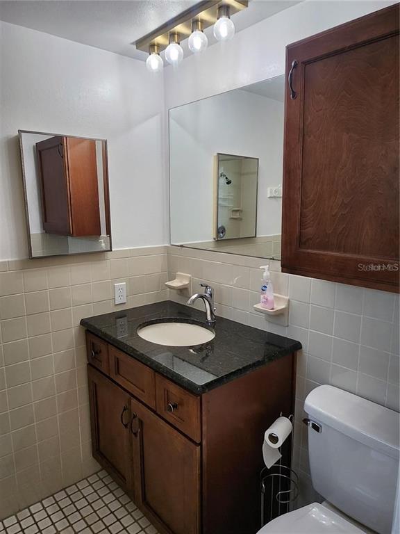 7021 Sonata Drive Port Richey, FL 34668 - Photo 4 of 14 a bathroom with a granite countertop sink a mirror and a toilet
