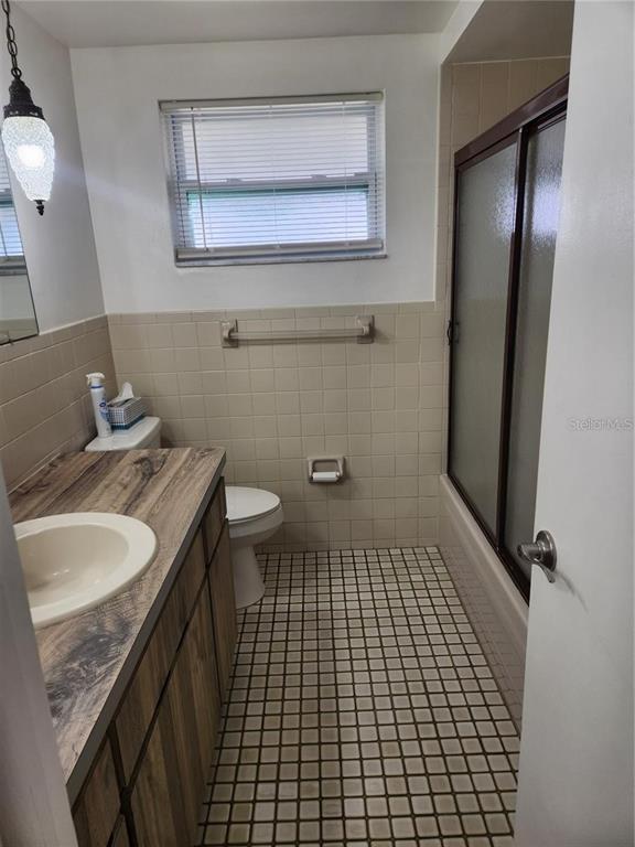 7021 Sonata Drive Port Richey, FL 34668 - Photo 5 of 14 a bathroom with a granite countertop sink a toilet and a mirror