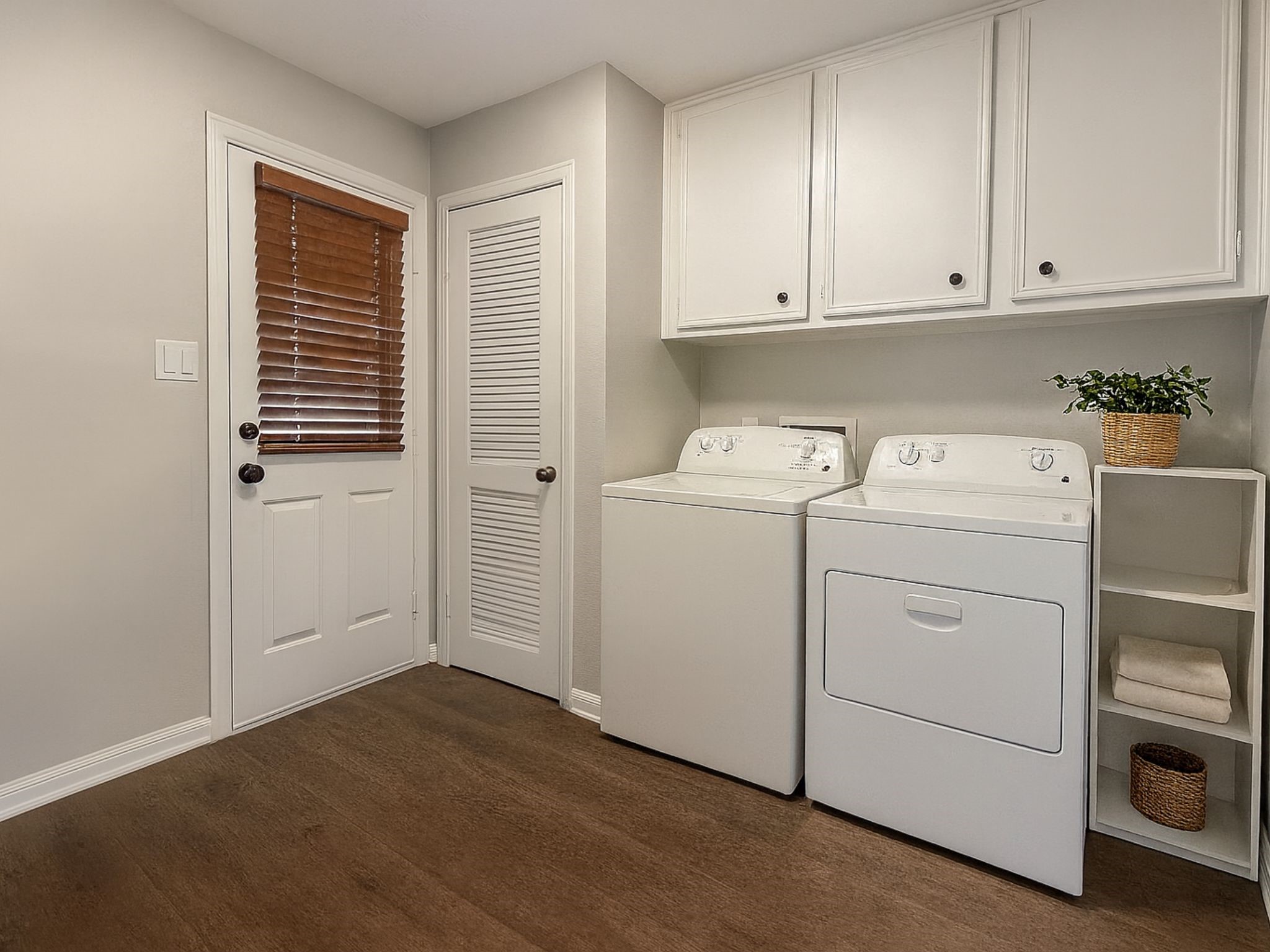 15619 Ripplewind Lane Houston, TX 77068 - Photo 24 of 31 a view of washer and dryer with wooden cabinets