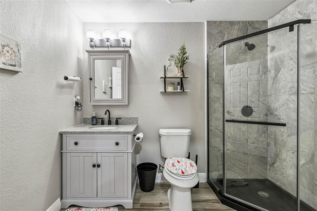 748 McClellan Road Frostproof, FL 33843 - Photo 13 of 31 a bathroom with a granite countertop sink toilet and shower