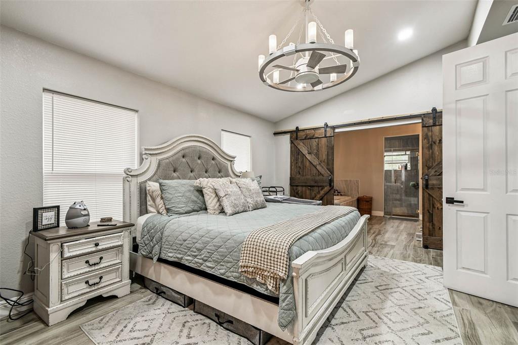 748 McClellan Road Frostproof, FL 33843 - Photo 17 of 31 a bedroom with a bed and a chandelier