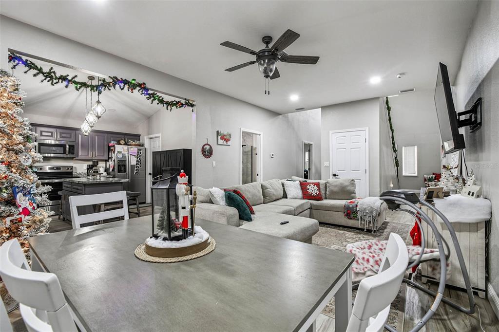 748 McClellan Road Frostproof, FL 33843 - Photo 21 of 31 a living room with furniture kitchen view and a chandelier