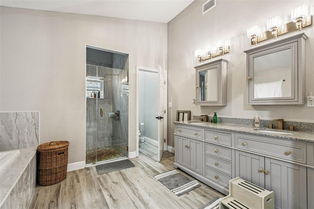 748 McClellan Road Frostproof, FL 33843 - Photo 23 of 31 a spacious bathroom with a double vanity sink a mirror and a shower