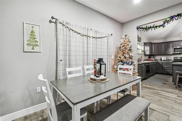 a kitchen with kitchen island stainless steel appliances a table and chairs in it