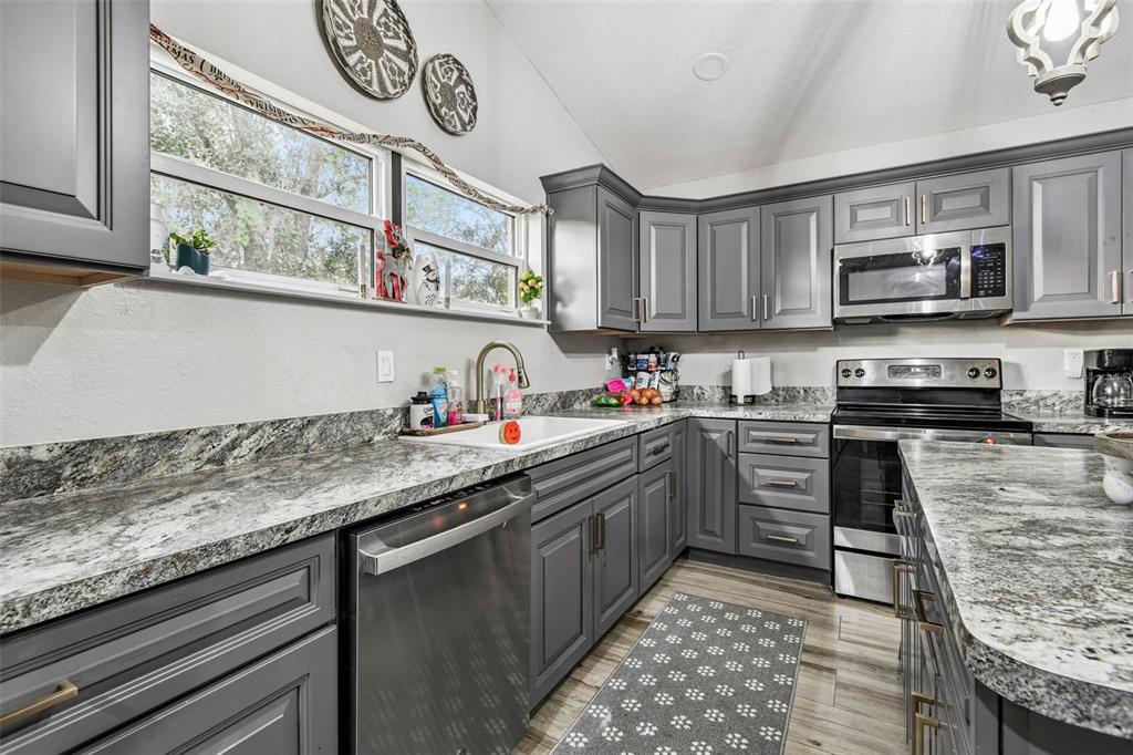 748 McClellan Road Frostproof, FL 33843 - Photo 8 of 31 a kitchen with stainless steel appliances granite countertop a sink and cabinets