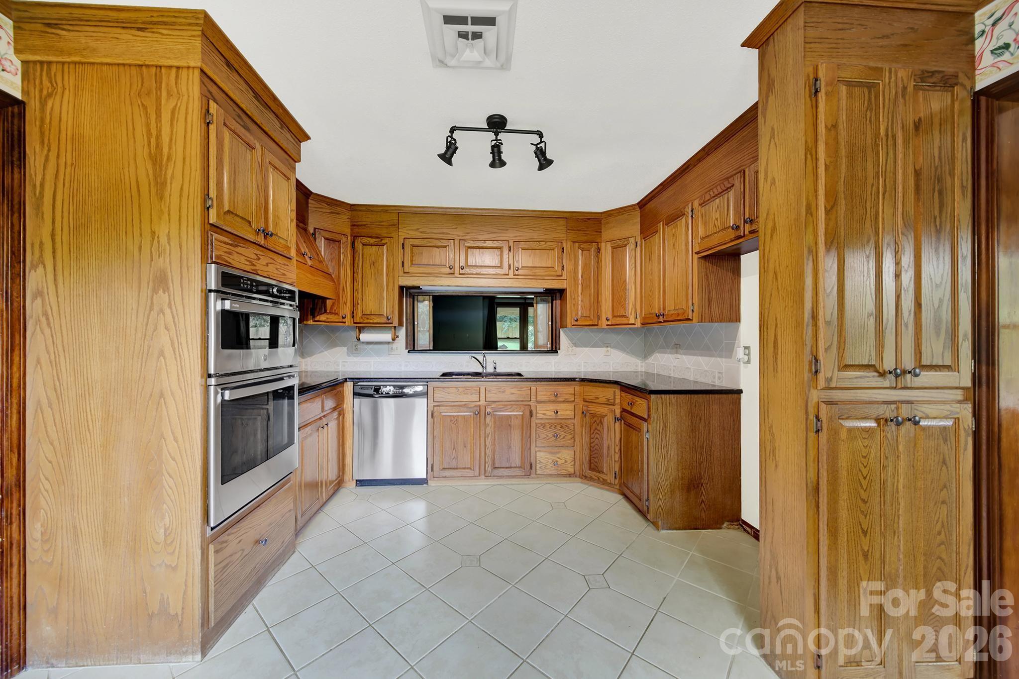 5913 Tom Query Road Charlotte, NC 28213 - Photo 14 of 47 a kitchen with stainless steel appliances granite countertop a refrigerator and a stove top oven