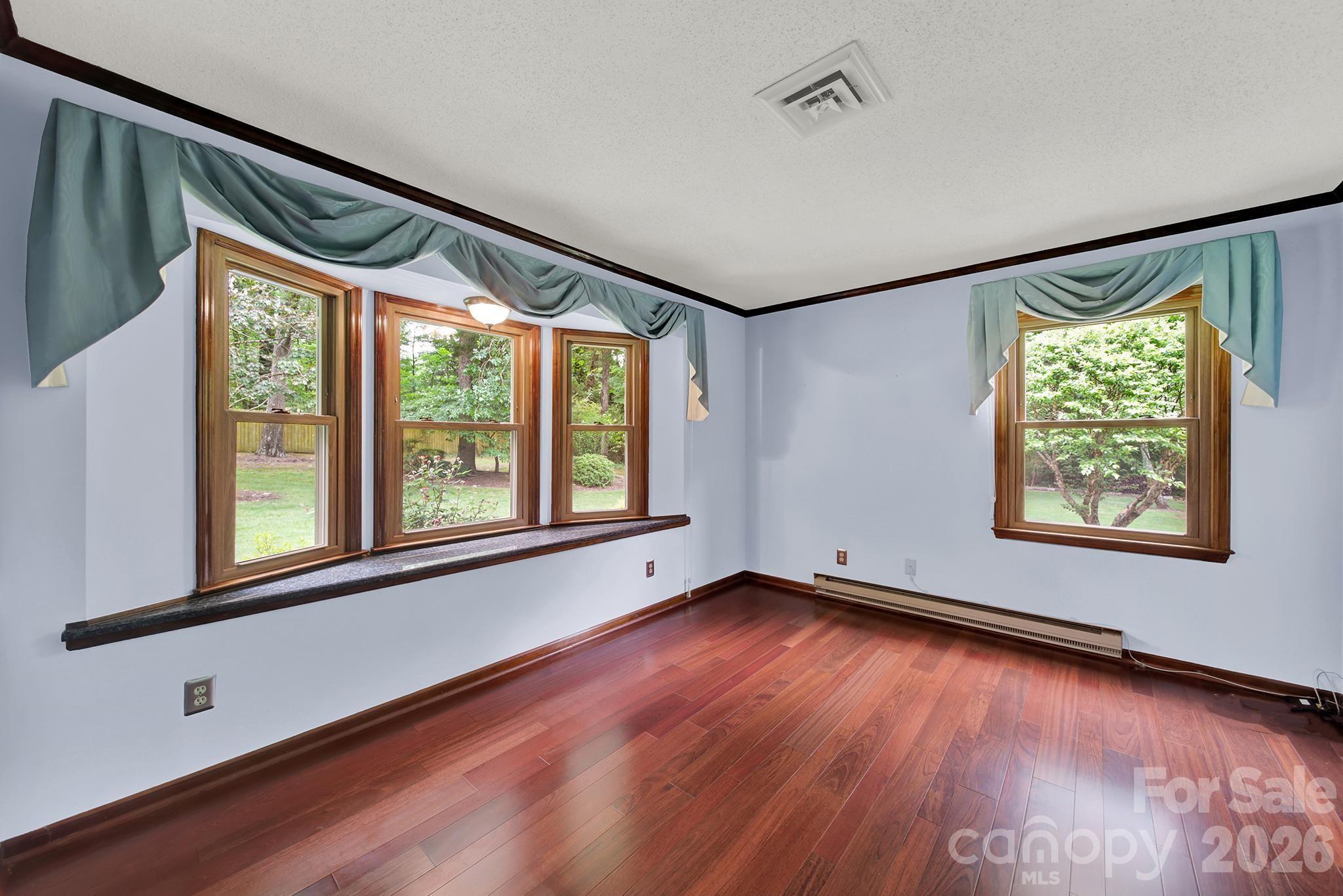 5913 Tom Query Road Charlotte, NC 28213 - Photo 16 of 47 an empty room with wooden floor and windows