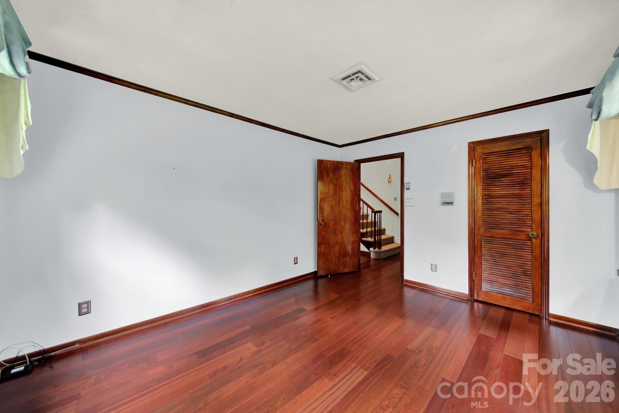 5913 Tom Query Road Charlotte, NC 28213 - Photo 17 of 47 an empty room with wooden floor and windows