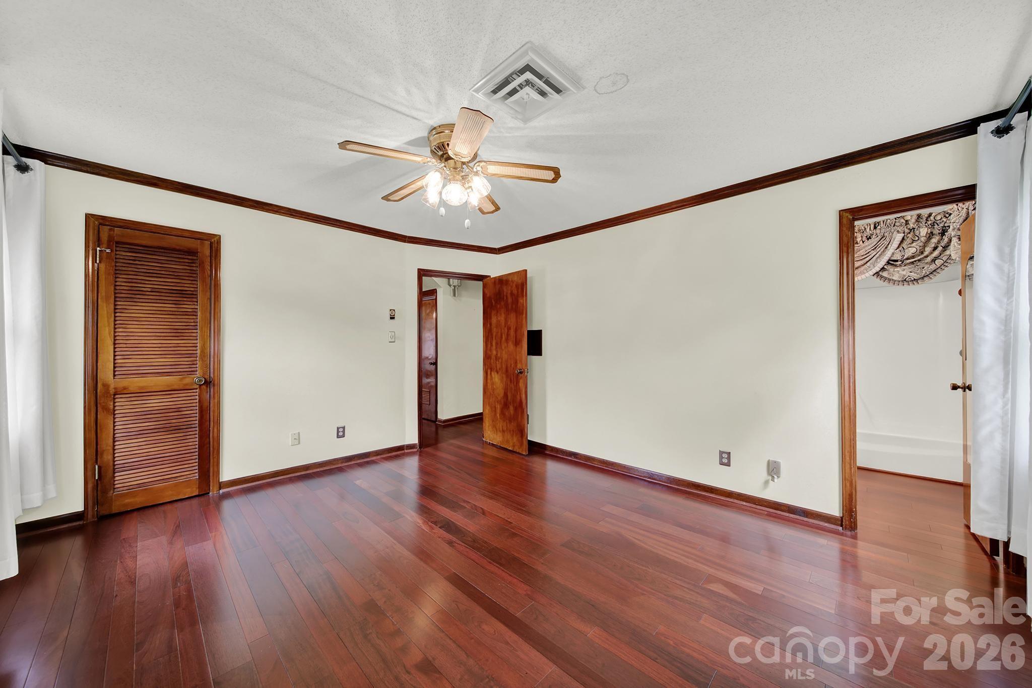 5913 Tom Query Road Charlotte, NC 28213 - Photo 20 of 47 an empty room with wooden floor chandelier fan and closet