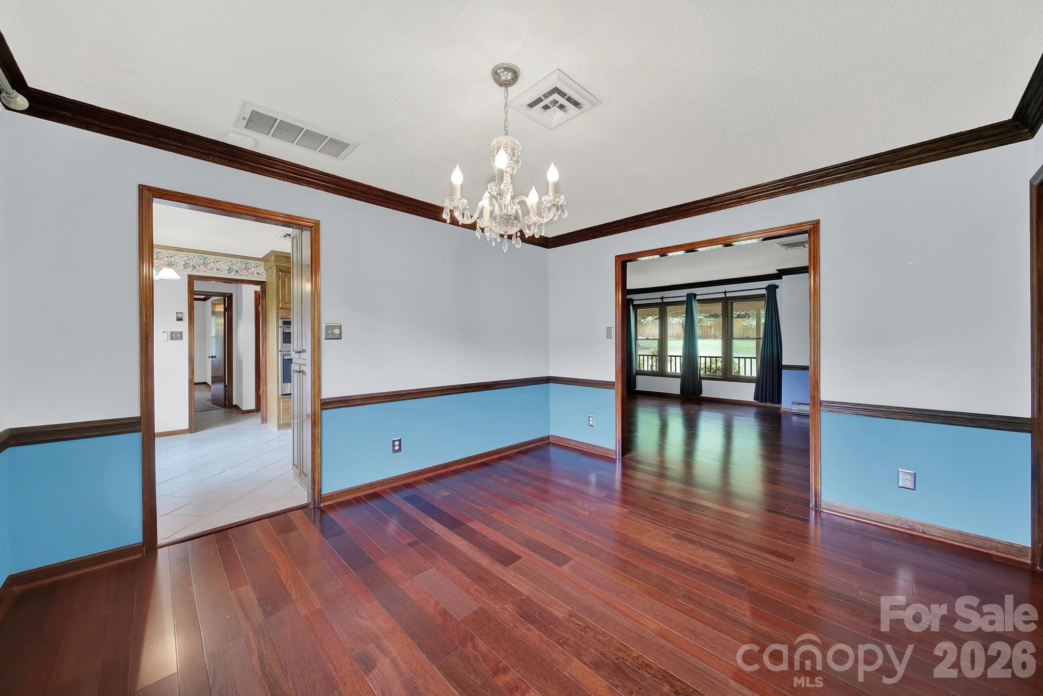 5913 Tom Query Road Charlotte, NC 28213 - Photo 10 of 47 a view of a room with wooden floor chandelier and windows