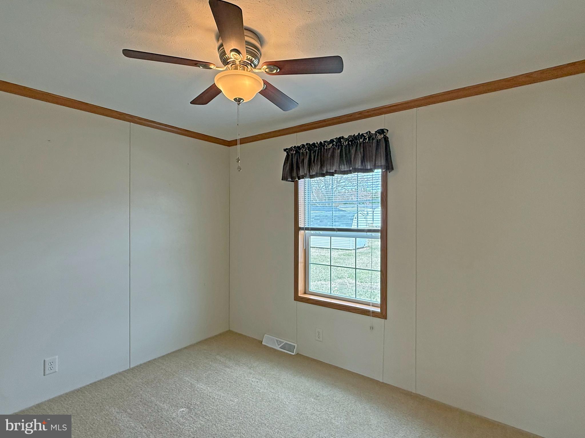 25 Baybreeze Road, Unit C29 Rehoboth Beach, DE 19971 - Photo 19 of 36 an empty room with windows and fan