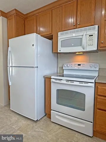 a kitchen with white cabinets and refrigerator