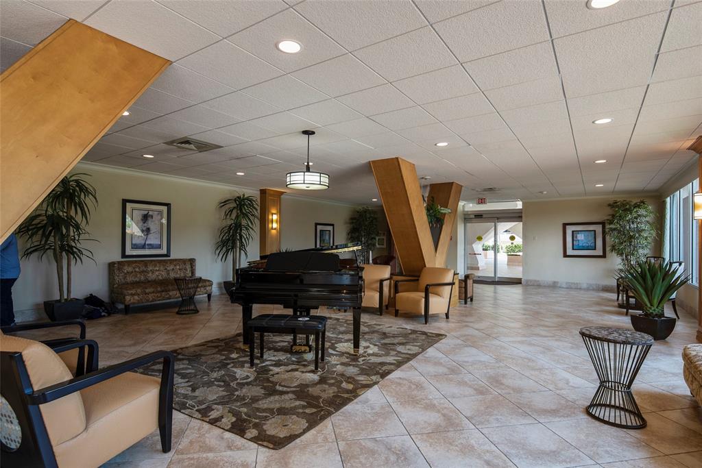 111 Briny Avenue, Unit 1805 Pompano Beach, FL 33062 - Photo 14 of 29 a living room with furniture a piano and a chandelier