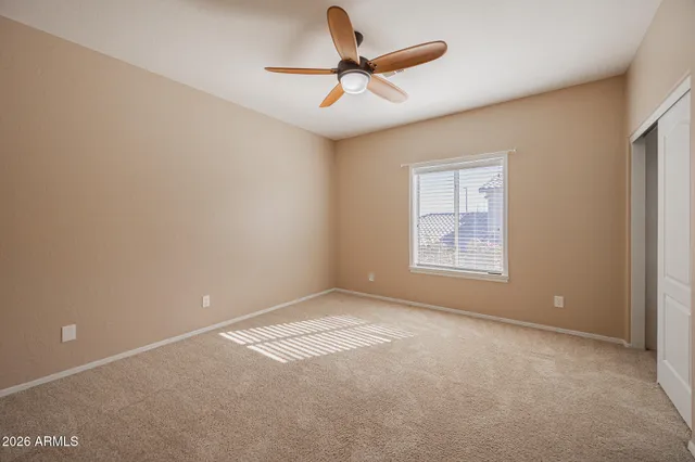 a view of a room with a ceiling fan and a window