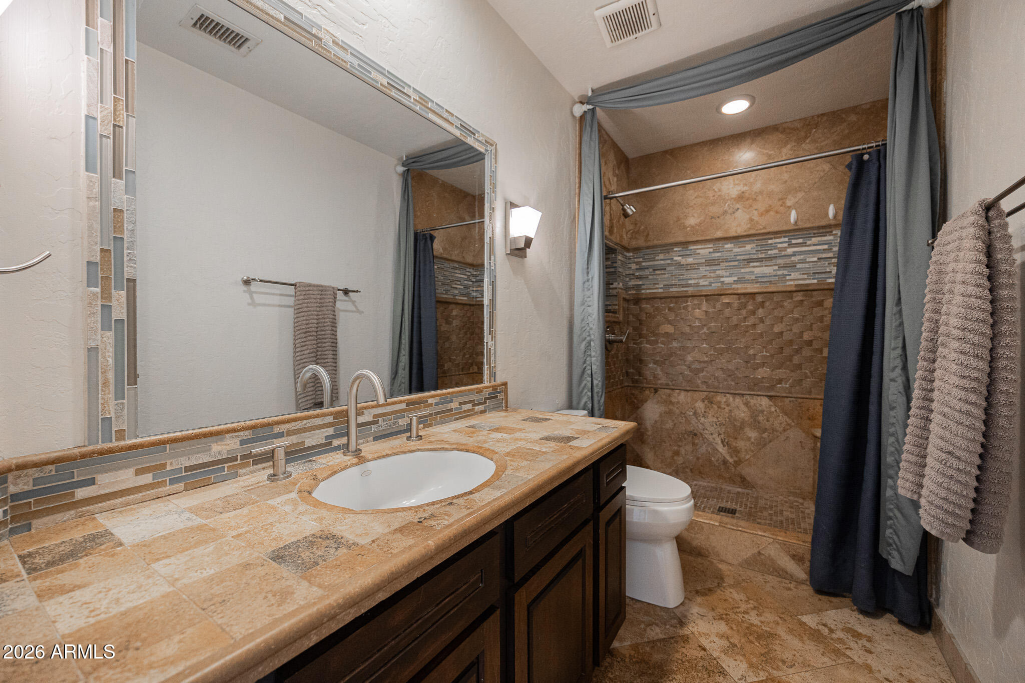 1767 West Redfield Road Gilbert, AZ 85233 - Photo 30 of 40 a bathroom with a granite countertop sink a toilet a mirror and shower