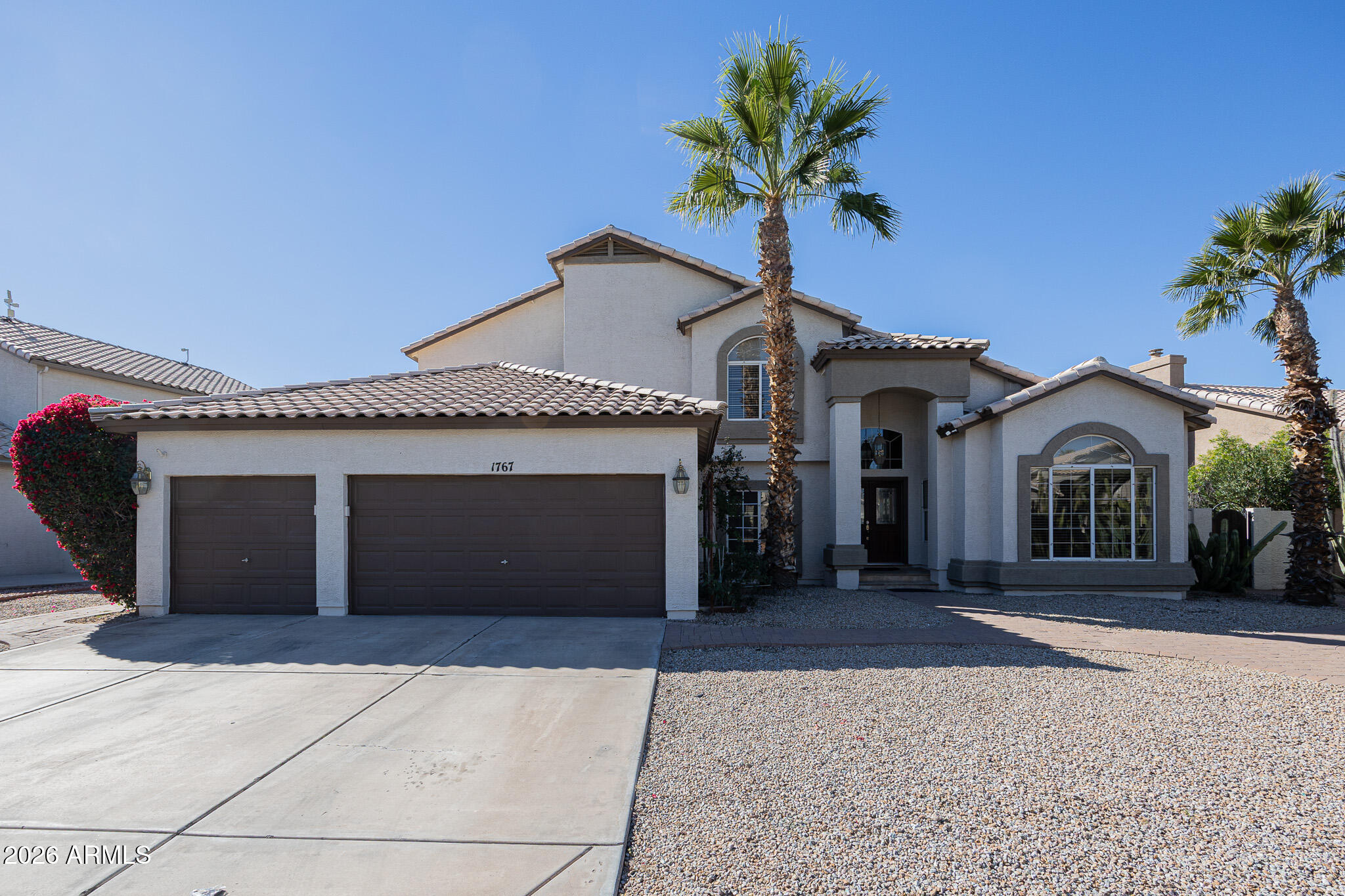 1767 West Redfield Road Gilbert, AZ 85233 - Photo 3 of 40 a front view of a house with a yard and garage