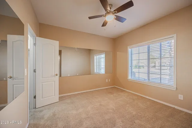 an empty room with fan and entrance