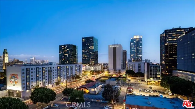 a view of a kitchen with kitchen island a sink wooden floor and a refrigerator