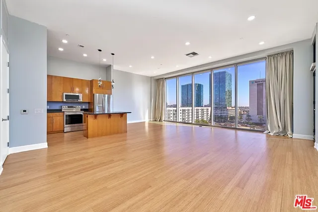 a kitchen with stainless steel appliances granite countertop a refrigerator and a stove top oven