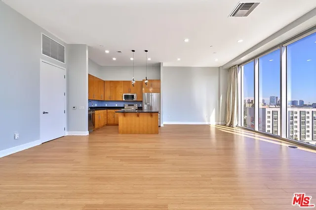 a view of kitchen with stainless steel appliances granite countertop cabinets and a wooden floor