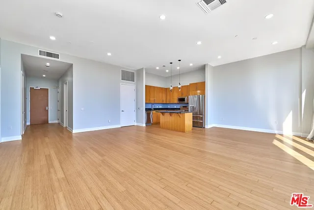 a kitchen with stainless steel appliances granite countertop a sink a stove and a refrigerator
